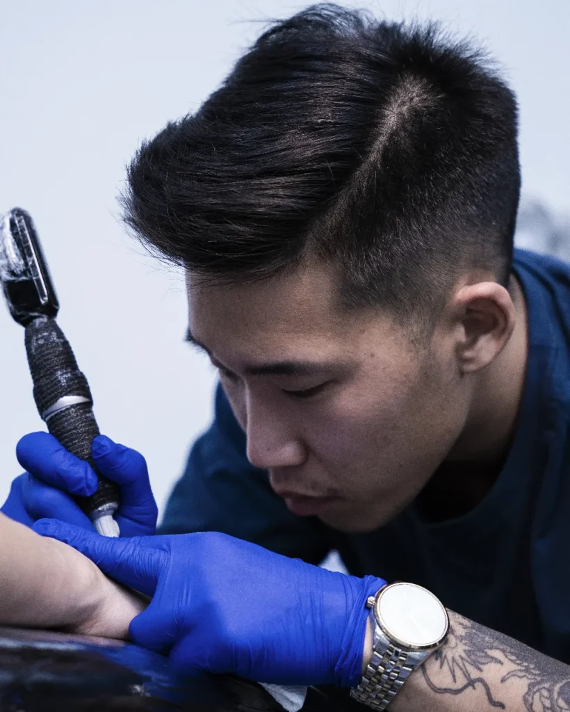 Artist hand-inking a lifelike realism tattoo at our Scarborough studio