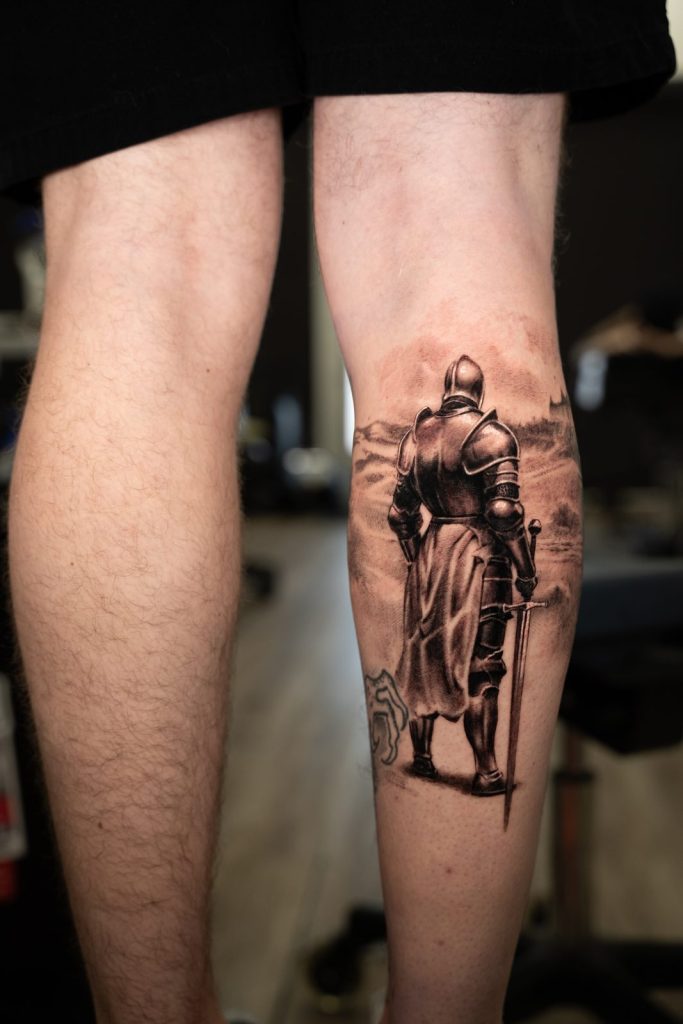Black and grey realism knight calf tattoo by The KCHN Tattoos, Scarborough