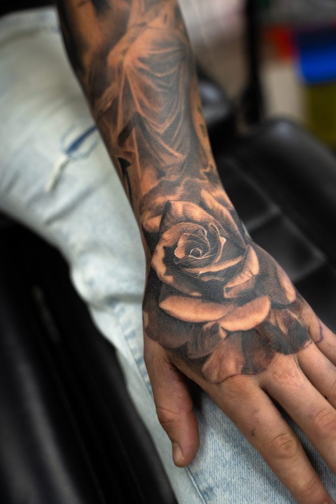 Black and grey realism rose hand tattoo by The KCHN Tattoos, Scarborough