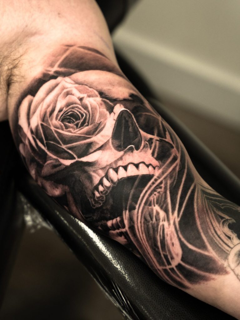 Black and grey realism skull rose forearm tattoo by The KCHN Tattoos, Scarborough