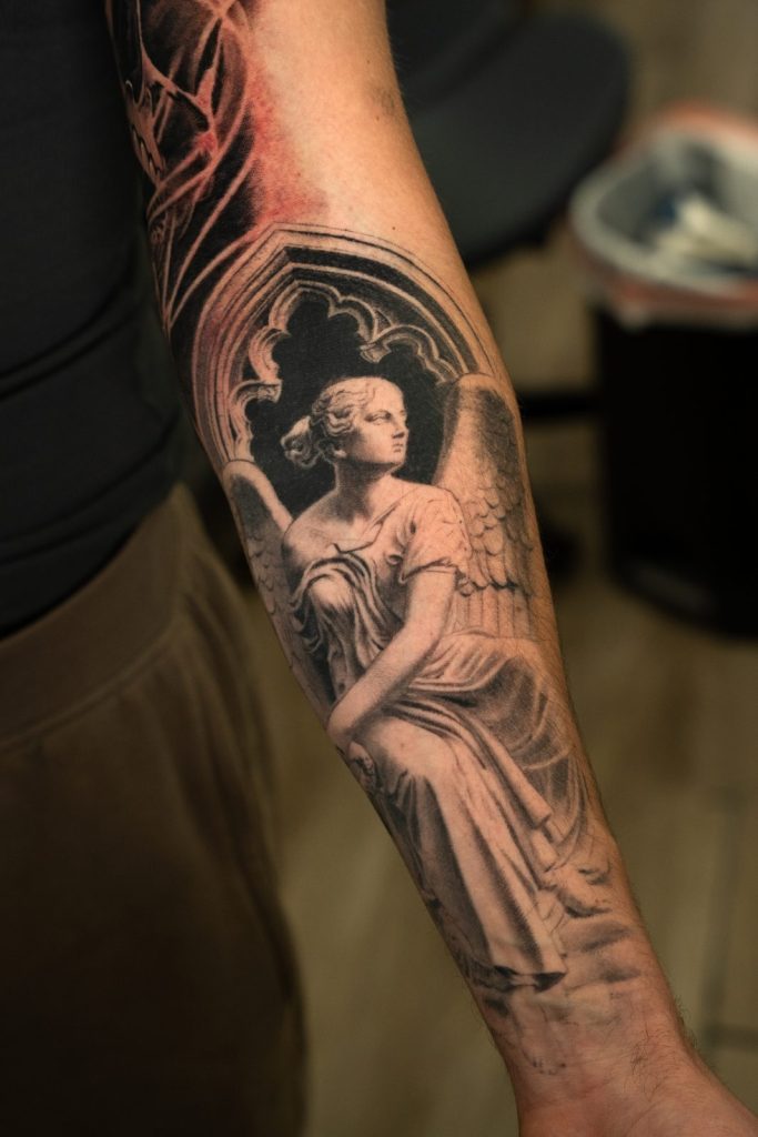Black and grey realism statue forearm tattoo by The KCHN Tattoos, Scarborough